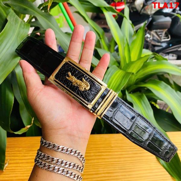 Hình ảnh thắt lưng da bụng cá sấu FBA9B2, viền bọc sang trọng, khóa vàng mạ vàng, cầm trên tay giữa lá xanh.