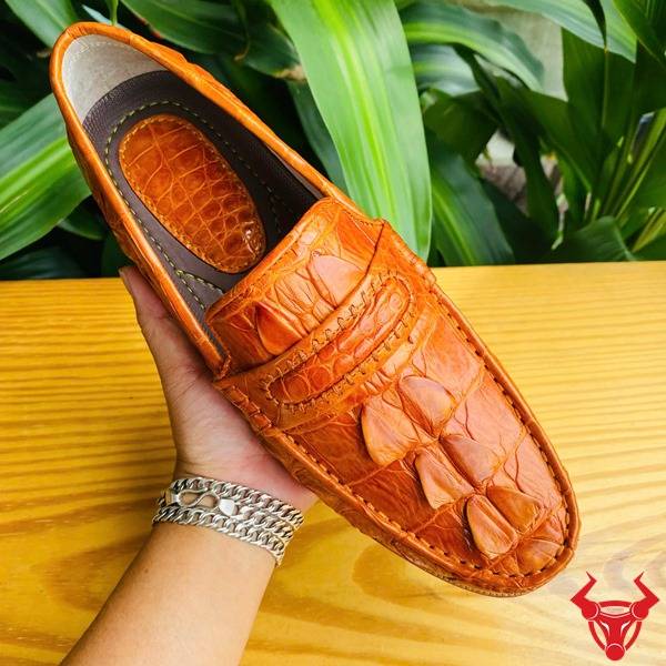 Ảnh đôi giày tây GCA2 da cá sấu gai đuôi màu vàng cam, nền lá xanh, cao cấp đẳng cấp quý ông.