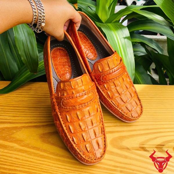Ảnh đôi giày tây GCA1 da gai lưng cá sấu màu vàng cam, nền lá xanh, cao cấp đẳng cấp quý ông.