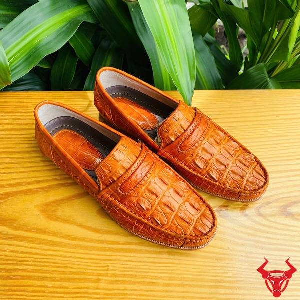 Ảnh đôi giày lười GCA1 da cá sấu màu vàng cam, nền lá, cao cấp đẳng cấp quý ông.