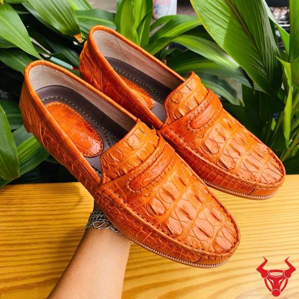 Ảnh đôi giày lười GCA1 da cá sấu màu vàng cam, nền lá xanh, cao cấp đẳng cấp quý ông.