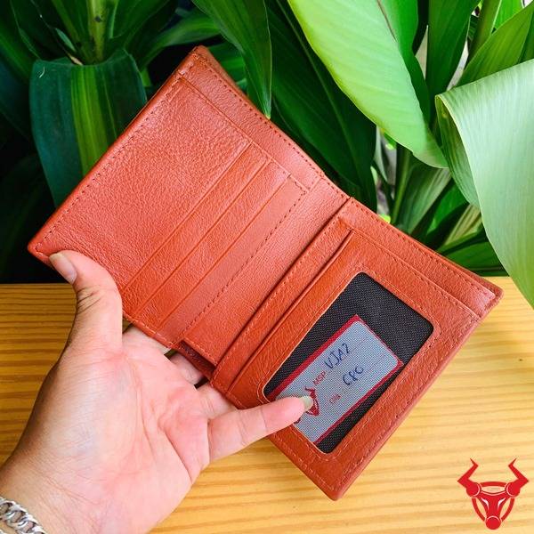 Hình ví đứng VJA2 da cá gai đuôi cá sấu màu nâu đỏ cầm tay, nền xanh, thể hiện cao cấp sang trọng cá tính.