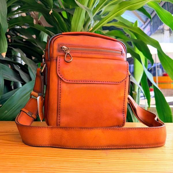 Cận cảnh bề mặt da bò Veg-tan của túi nam A19 màu cam.