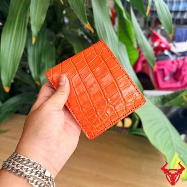 Ví da bụng cá sấu màu cam được gia công tỉ mỉ và chắc chắn.