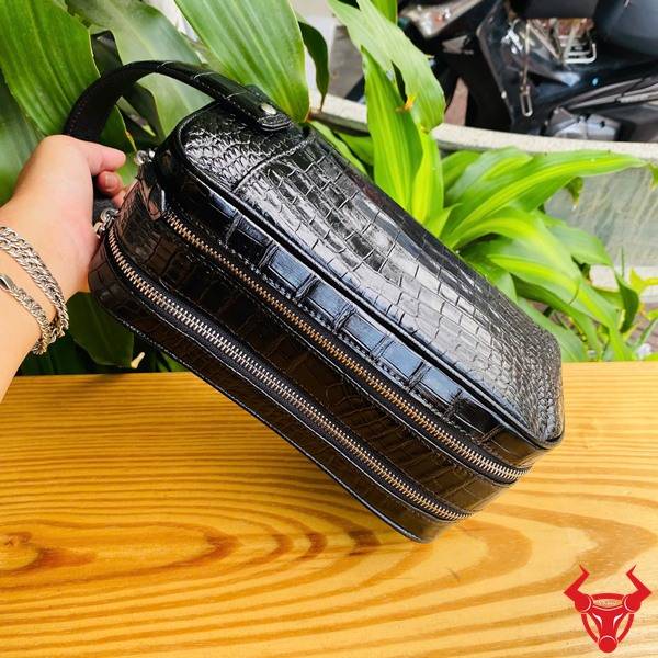 Clutch xách tay da bụng cá sấu CGA8 màu đen với thiết kế hai ngăn khóa kéo.