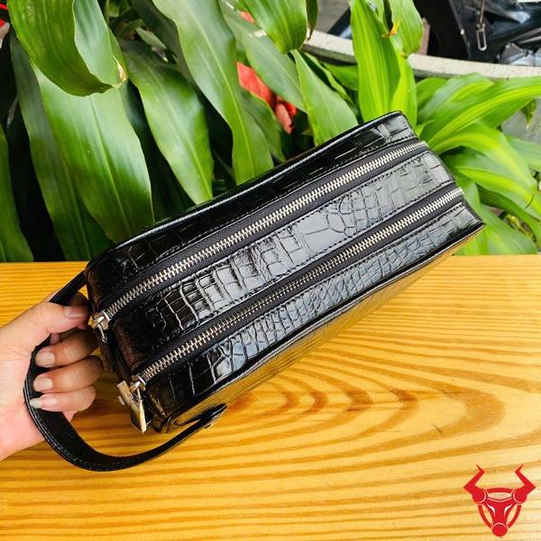 Clutch da bụng cá sấu CGA8 màu đen chế tác tinh xảo với hai ngăn khóa kéo.